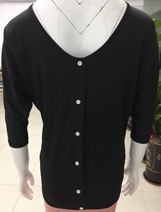 Close-up of stylish white buttons decorating the back of a black V-neck top
