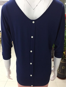 Detail view of the back button closure and V-neckline on a navy blue batwing sleeve top