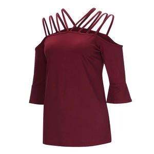 Detail of wine red cold-shoulder top featuring criss-cross straps and flared sleeves