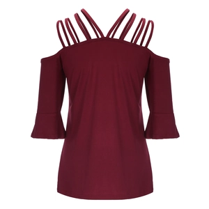 Detail of burgundy cold-shoulder top with multiple straps and elegant bell sleeves