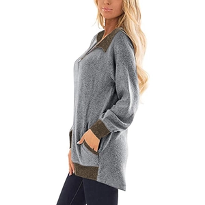 Détail d'un sweat gris avec bord-côte marron et poche latérale au niveau de la hanche