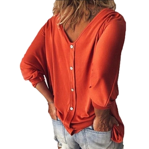 Orange V-neck top with batwing sleeves and decorative white buttons on the back