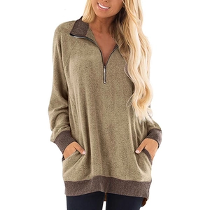 Détail du col zippé 1/4 et poignets contrastés sur le sweat-shirt vert à manches longues