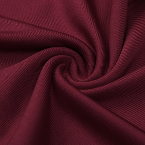 Macro shot of wine red ribbed knit fabric with soft vertical texture and premium silk finish