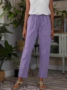 Detail of light purple cotton linen trousers with elastic drawstring waist and large pockets