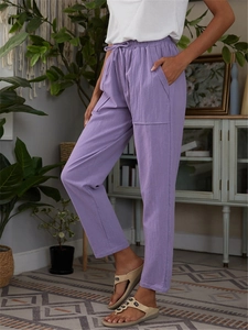 Detail of light purple linen pants featuring an elastic drawstring waist and large side pockets