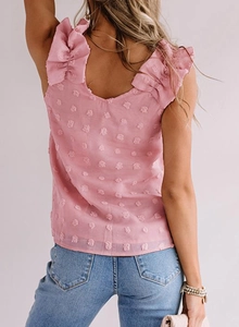 Détail d'un haut rose sans manches en tissu plumetis avec volants et col en V au dos