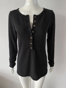 Détail d'un t-shirt Henley côtelé noir avec patte à sept boutons et encolure ronde classique
