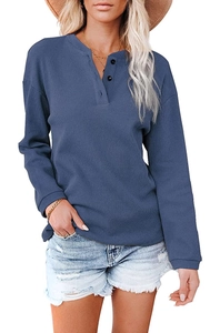 Detailed macro view of dark blue waffle knit fabric texture and three-button Henley neckline