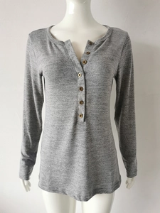 Vue détaillée du col Henley gris avec sept boutons en bois foncé sur le t-shirt manches longues