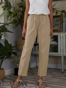 Detailed view of elastic waist with drawstring and large pockets on cotton linen pants
