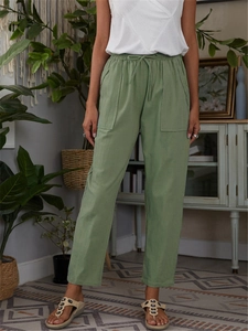 Detail of green cotton linen casual trousers with elastic drawstring waist and large pockets
