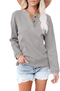 Close-up of gray ribbed knit fabric and three-button V-neck detail on the long sleeve top