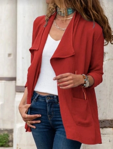 Détail d'un trench-coat rouge à manches longues en tissu crêpé avec grands revers