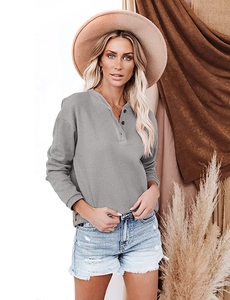 Close-up of grey long-sleeve Henley tee with ribbed texture and three-button neckline