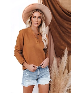 Close-up of ginger waffle knit fabric texture and Henley V-neck with three buttons