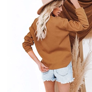Detailed side view of a camel ribbed long sleeve V-neck top with raw hem denim shorts
