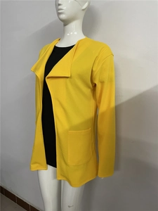 Détail d'un manteau long jaune à manches longues avec grand revers et texture gaufrée
