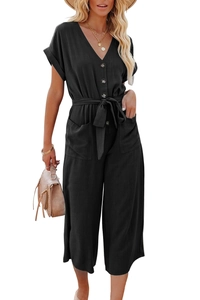 Détail d'une combinaison noire à col en V avec ceinture à nouer et poches latérales