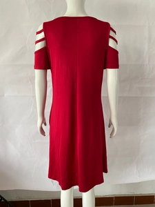 Detail of red cold shoulder dress showing cutout straps on shoulders and straight silhouette