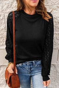 Detailed view of the waffle knit texture and delicate lace stitching on black sleeves