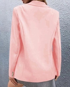 Rear view of a light pink tailored blazer showing clean lines and buttoned cuffs