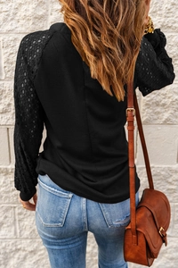 Detail of waffle knit top showing black lace patchwork sleeve and soft fabric texture