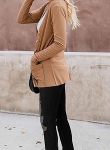 Detail view of camel ribbed knit cardigan showing button closure and side pocket design