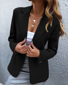 Detail of a casual black long-sleeve blazer with notched lapel and coin necklace