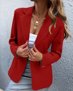 Close-up of women's red blazer with notch lapel and layered golden disc necklace