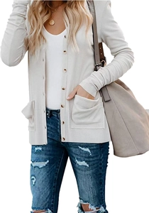 Detail of white ribbed knit cardigan featuring amber buttons and side pockets on a model