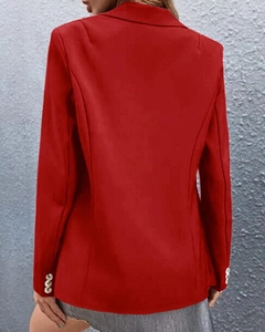 Rear view of women's red casual blazer featuring three decorative gold buttons on sleeves