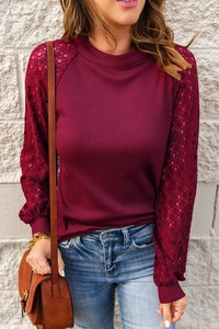 Close-up of wine red waffle knit texture and elegant hollow lace sleeves on long sleeve top