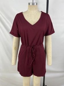 Detail of burgundy ribbed romper featuring a V-neckline and adjustable waist drawstring