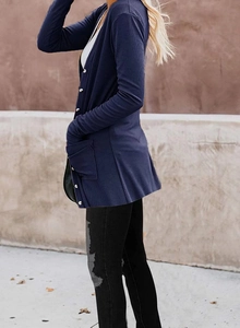 Detailed close-up of ribbed knit texture and white buttons on dark blue cardigan