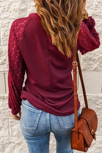 Detail of wine red waffle knit top with elegant lace hollow sleeve stitching for women