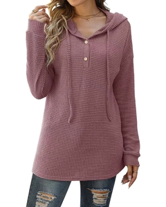 Détail du pull à capuche en maille gaufrée avec décolleté boutonné et texture rose doux