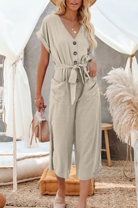 Détail d'une combinaison beige avec col en V, grands boutons foncés et ceinture ajustable
