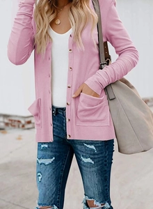Close-up of pink knit cardigan with ribbed texture and front button pockets