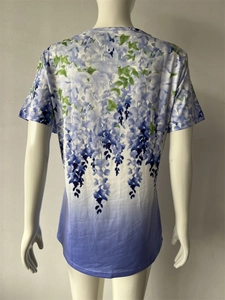 Dettaglio della stampa floreale e sfumatura blu-viola sulla t-shirt a maniche corte