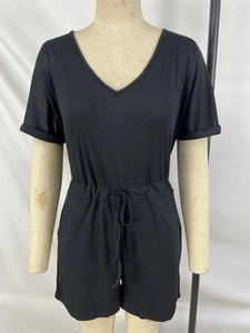 Detail of black V-neck short sleeve jumpsuit with ribbed texture and drawstring waist