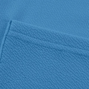 Gros plan sur la maille gaufrée bleu vif avec coutures doubles sur la poche de la veste