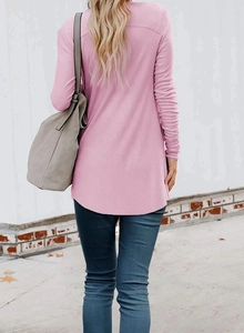 Back view of a pink ribbed long-sleeve cardigan with curved hem styled with blue jeans