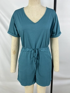 Detail view of cyan ribbed knit texture with elastic drawstring waist and V-neckline
