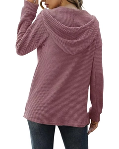 Détail de la texture en maille gaufrée et capuche d'un pull d'automne ample vue de dos