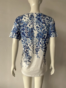 Dettaglio di stampa floreale acquerello blu su t-shirt estiva bianca in cotone da donna