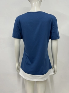 Detail view of the layered hem and pleated back of this navy blue short sleeve t-shirt