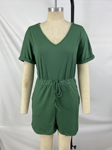 Detail of ribbed dark green V-neck romper featuring rolled sleeves and drawstring waist