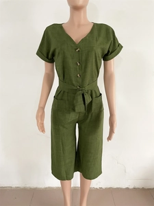 Détail d'une combinaison vert olive avec col en V, boutons en bois et ceinture