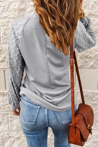 Detail of grey waffle knit fabric and elegant hollow lace splicing on the long sleeve top